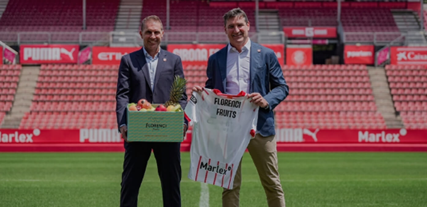Wide shot striker kicking ball inside crowded stadium
